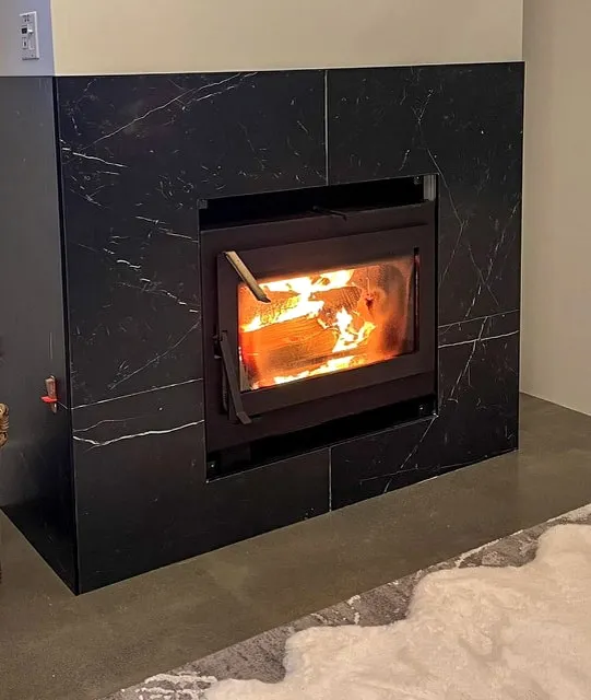 Black marble fireplace surround with a lit fire