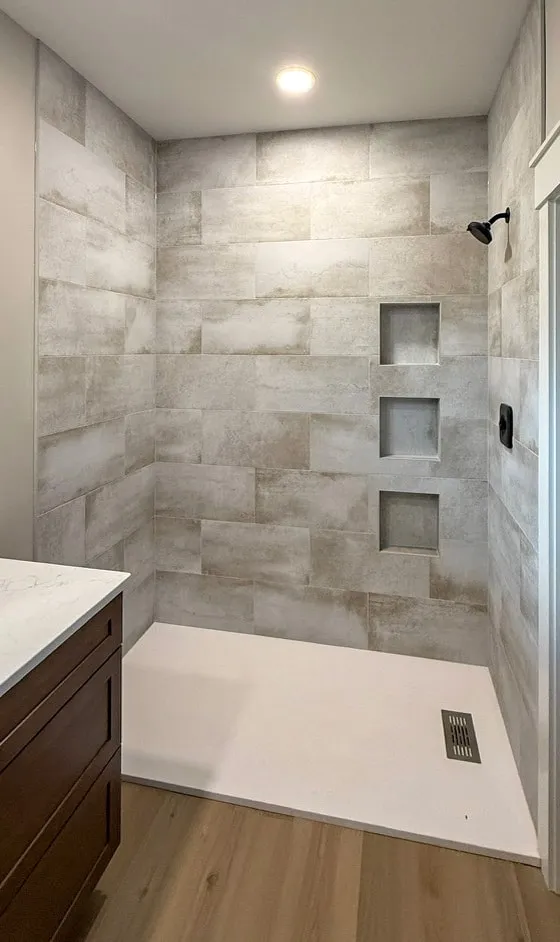 Concrete-look shower with three stacked niches and a low-profile pan